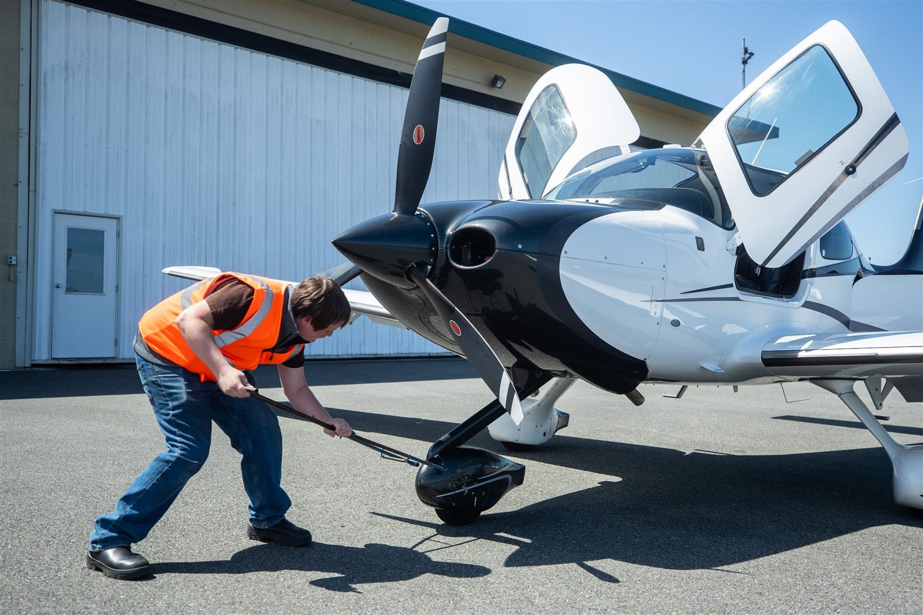 A Citizen Air line technician towing the Cirrus SR22 out of the hangar
